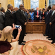 Shoes still on, Counselor to the President Kellyanne Conway takes a photo Tuesday in the Oval Office. Seeing other photos from the session, some commentators on social media thought Conway was texting. (Pool photo by Brendan Smialowski/Agence France-Presse)